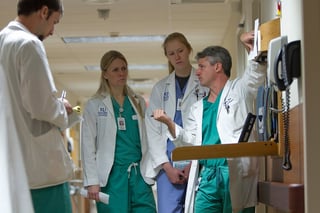 team of doctors and nurses standing in hospital hallway