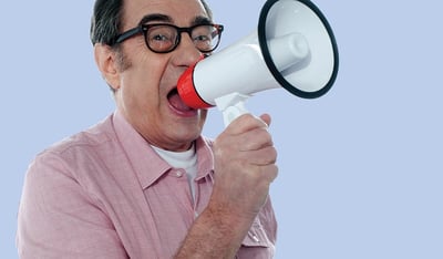an older man yelling into a bullhorn