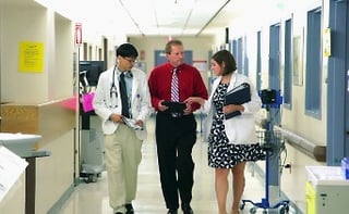 hospital staff walking and talking in a corridor