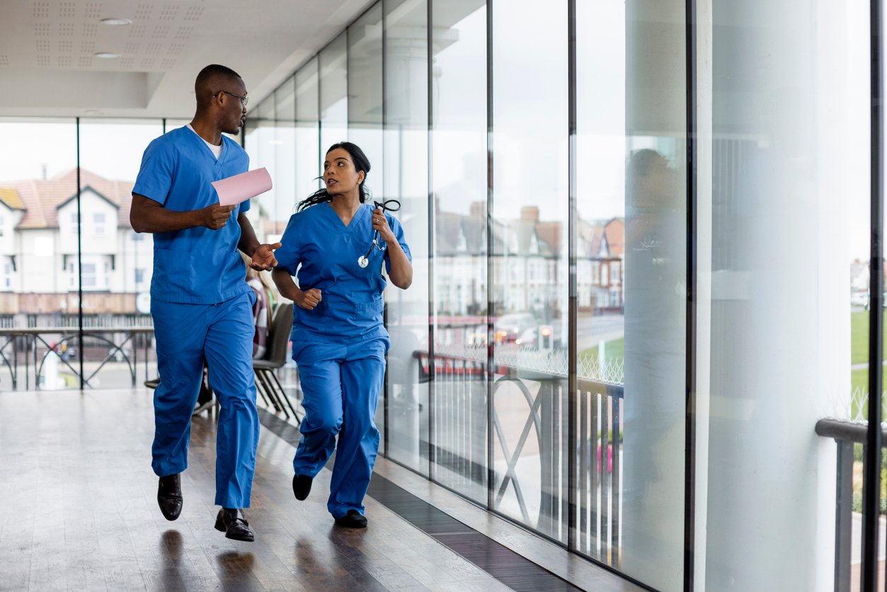 Two Nurses Running in the Hospital Hallway