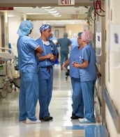 nurses in scrubs standing in a hospital hallway