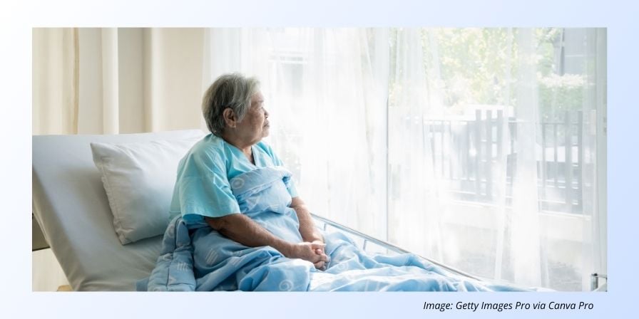 elderly woman in hospital bed looking out the window