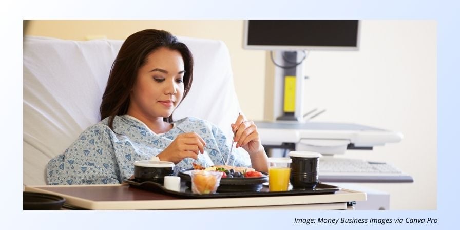 patient in hospital bed eating on tray